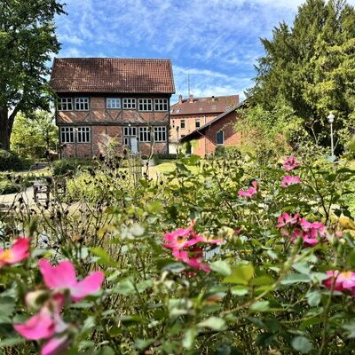 Foto vom Königin Christinenhaus. Im Vordergrund Blumen 